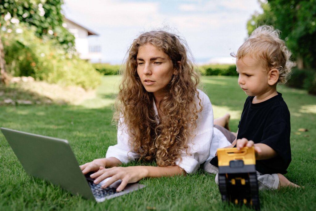Life coach for women looking at her laptop with her son.