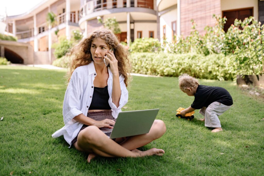 Life coach for women on the phone working outside with her toddler.